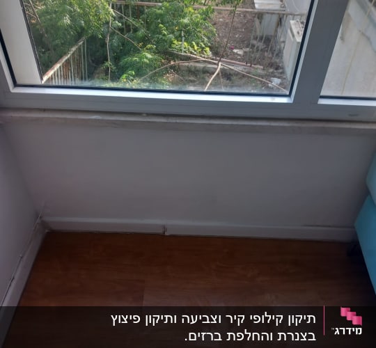 רצפת עץ ליד חלון עם מסגרת לבנה